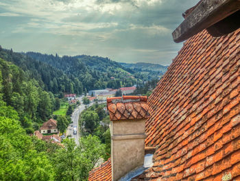 Houses amidst trees and buildings against sky