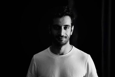 Portrait of young man smiling in darkroom