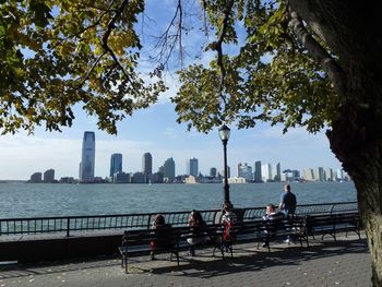 People sitting on bridge in city