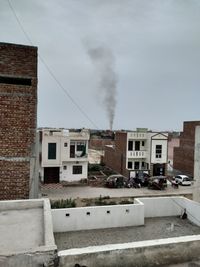 Smoke emitting from chimney against sky