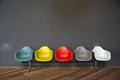 Colorful seats on hardwood floor against gray wall