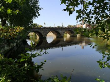 Arch bridge over river against sky