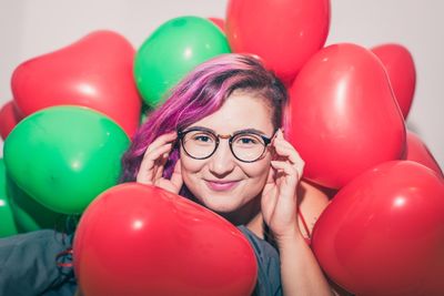 Portrait of woman with red balloons