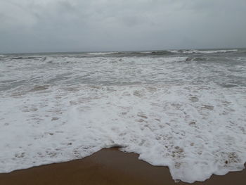 Close-up of waves on beach against sky