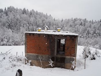 Built structure on snow covered mountain against sky