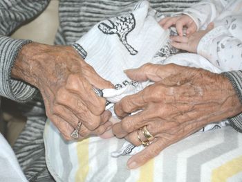 Midsection of woman with hands on bed