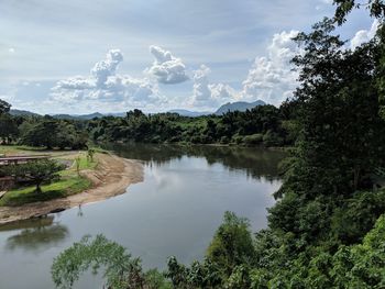 Scenic view of river by trees against sky