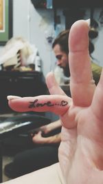 Cropped hand of woman with love text tattoo