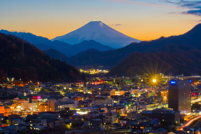 High angle view of illuminated cityscape against sky during sunset