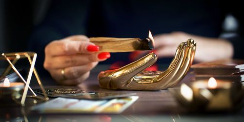 Cropped hand of woman holding wineglass on table