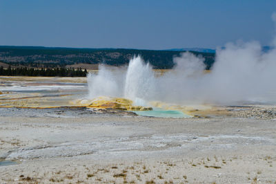 Scenic view of geyser against sky