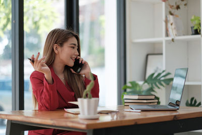 Smiling businesswoman talking on phone at office