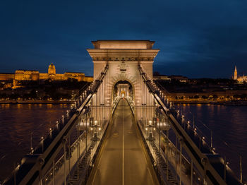 Bridge over river against sky at night