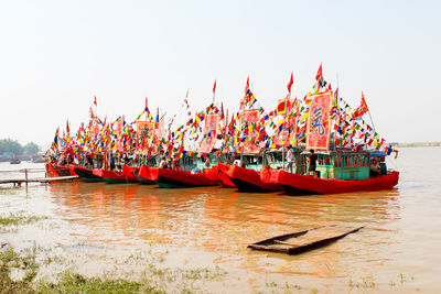 Boats moored in river against clear sky