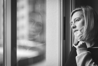 Thoughtful woman looking through window