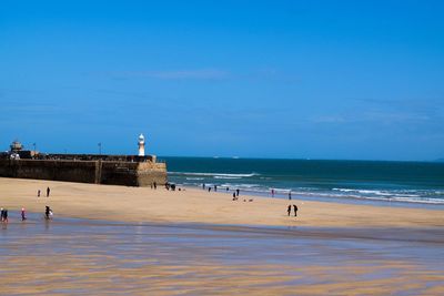 Scenic view of beach and sea against blue sky