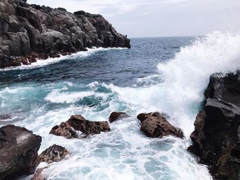 Sea waves splashing against rock formation