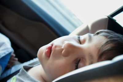 Close-up of boy sleeping in car