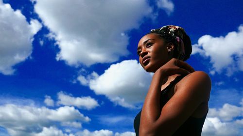 Low angle view of woman looking away against sky