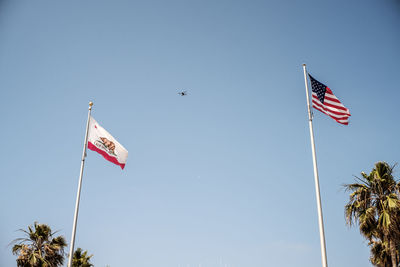 Low angle view of flag against clear blue sky