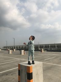Boy standing on promenade against sky