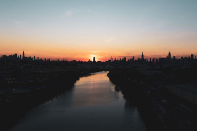 Silhouette of buildings in city during sunset