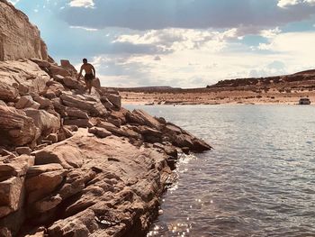 People on rock formations against sky