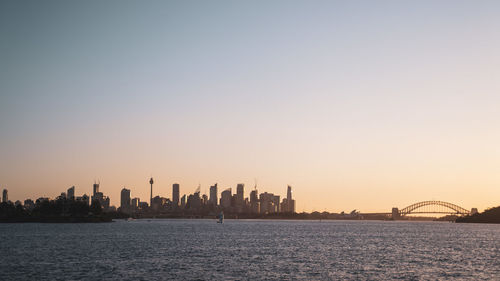 Scenic view of sea and buildings against clear sky