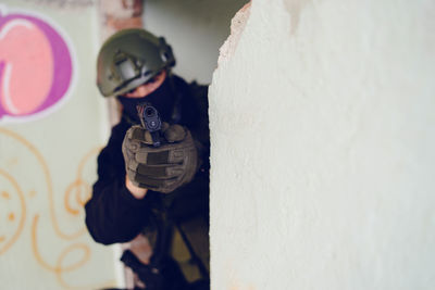 Army soldier aiming gun in building