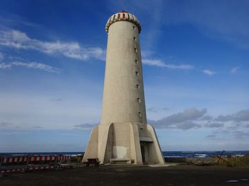 Low angle view of lighthouse by sea against sky