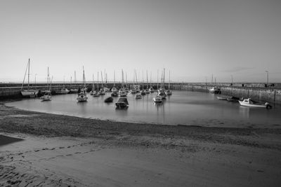 Sailboats moored in sea against clear sky