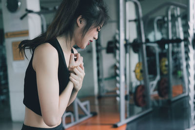 Young woman suffering from joint pain while exercising in gym