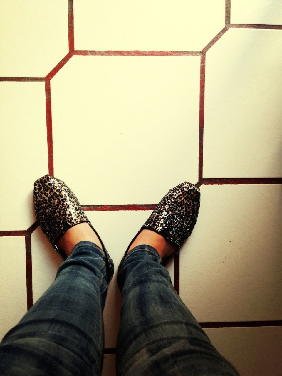 low section, indoors, person, personal perspective, shoe, standing, lifestyles, tiled floor, human foot, directly above, part of, high angle view, men, flooring, jeans, pattern, footwear