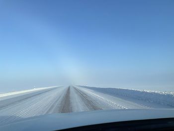 Road against sky seen through car windshield