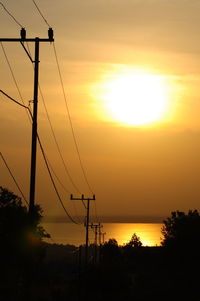 View of the road to the beach with silhouettes of electric poles along the roadside