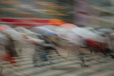 Defocused image of people walking on street in city