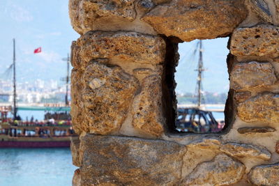 Close-up of stone wall with sea in background