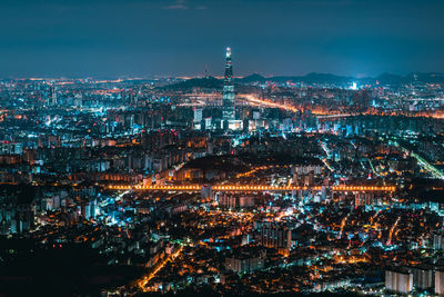 High angle view of illuminated cityscape against sky at night