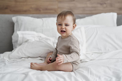 Portrait of cute girl using digital tablet while lying on bed at home