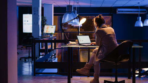 Side view of woman sitting on chair