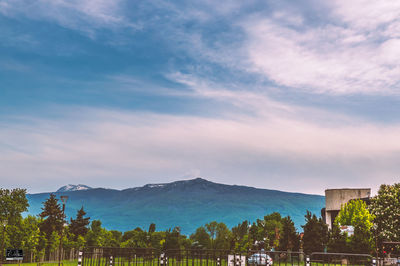 Panoramic view of buildings against cloudy sky