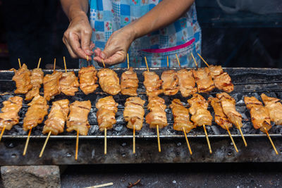 Midsection of man preparing food on barbecue grill