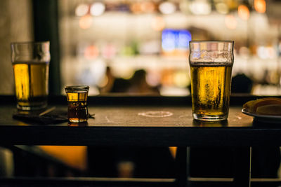 Close-up of beer glasses on table