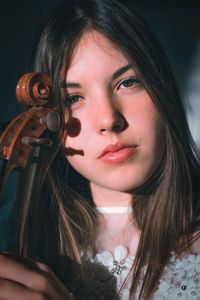 Portrait of beautiful young woman holding violin