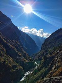 Scenic view of mountains against bright sun