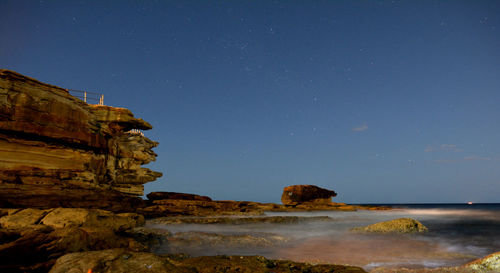 Scenic view of rocky coastline at night