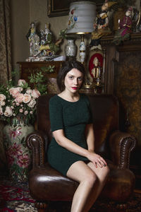 Portrait of woman sitting on chair at home