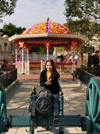Portrait of smiling young woman sitting outdoors