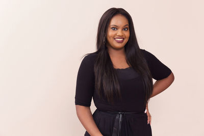 Portrait of smiling young woman against white background