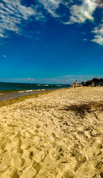 Scenic view of beach against blue sky